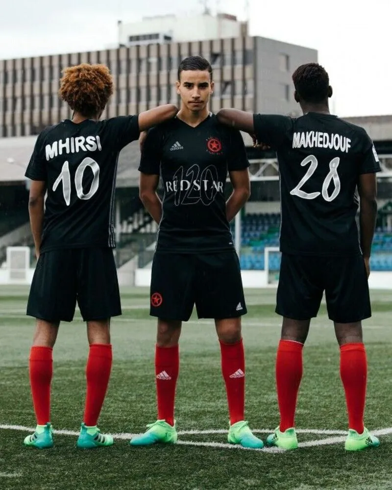 players wearing black soccer uniforms standing in ground