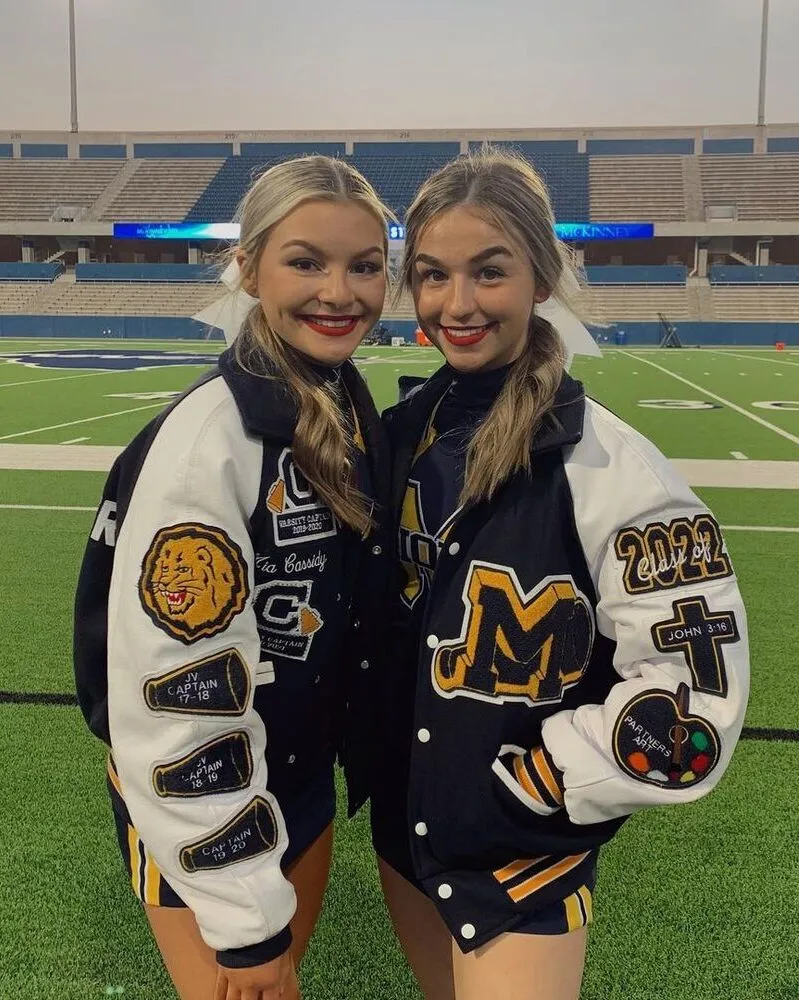 a local school cheerleading team girls wearing blue letterman jackets with white sleeves custom chenille patches on shouders