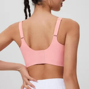 The back view of a woman wearing a light pink sports bra with thin adjustable straps and a wide comfortable back band.