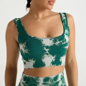 A close-up of a woman wearing a dark teal and white tie-dye patterned sports bra made from a textured ribbed fabric.