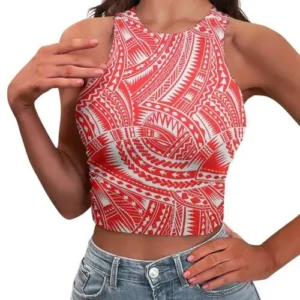 A woman wearing a red and white geometric tribal print crop top with a high halter neckline, paired with denim jeans.
